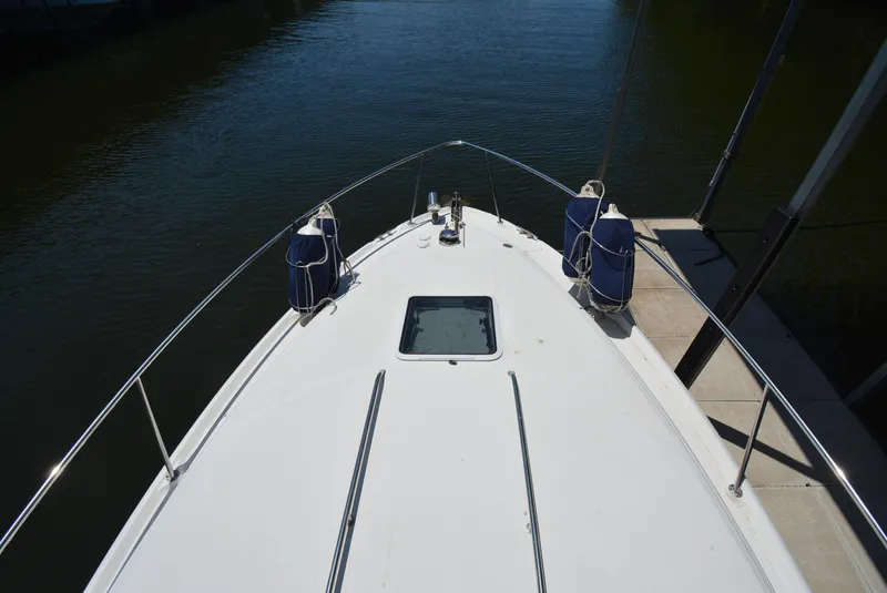 Slide: The Image of Bow view of 2004 Sea Ray 300 Sundancer docked, featuring sleek design and water reflection. - 21