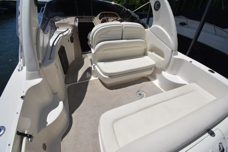 Slide: The Image of 2004 Sea Ray 300 Sundancer boat interior with white seating and helm. - 32