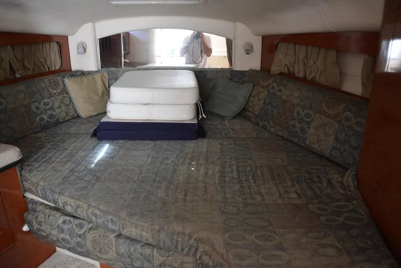 Slide: The Image of Interior cabin of 2004 Sea Ray 300 Sundancer with cushioned seating and bedding. - 37
