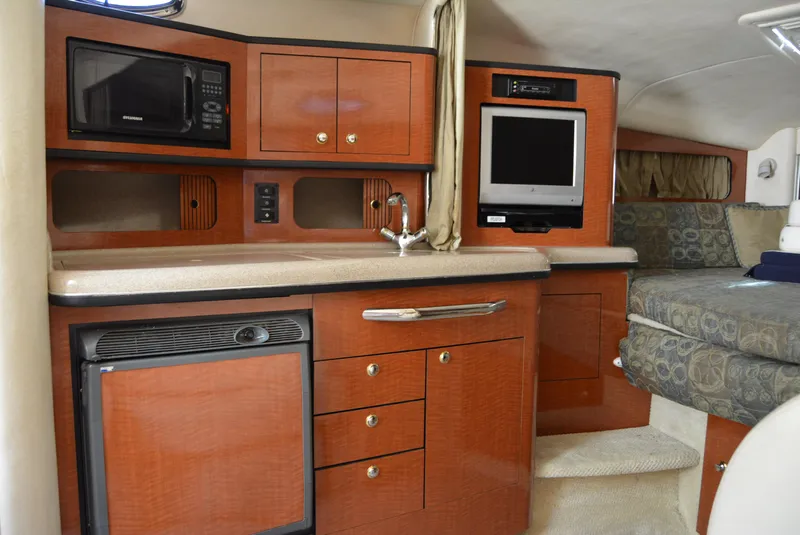 Slide: The Image of 2004 Sea Ray 300 Sundancer interior with kitchenette, microwave, TV, and seating area. - 41