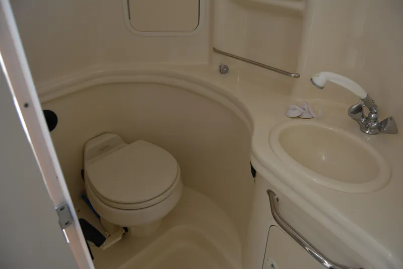 Slide: The Image of Compact bathroom in 2004 Sea Ray 300 Sundancer boat, featuring toilet and sink. - 42