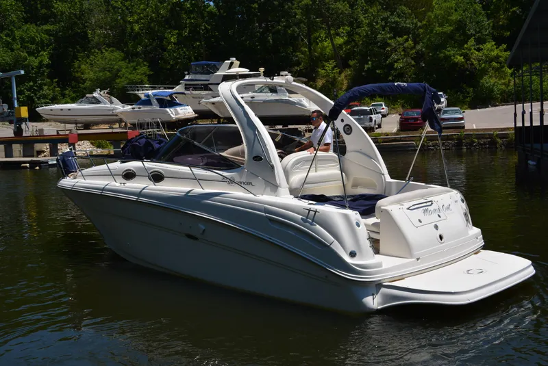 Slide: The Image of 2004 Sea Ray 300 Sundancer boat docked on a sunny day, surrounded by lush greenery. - 6