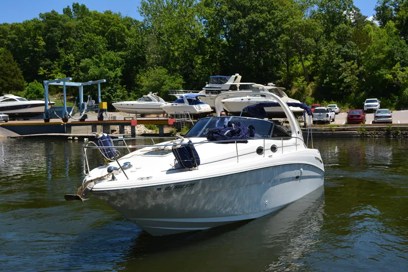 Slide: The Image of 2004 Sea Ray 300 Sundancer boat docked in a marina with lush greenery. - 7