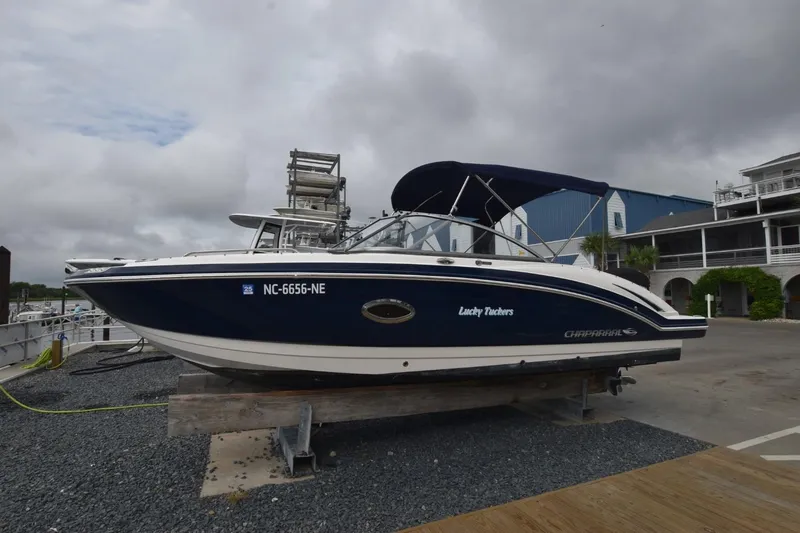 Slide: The Image of 2018 Chaparral 230 Suncoast boat on dry dock, blue hull, overcast sky. - 1