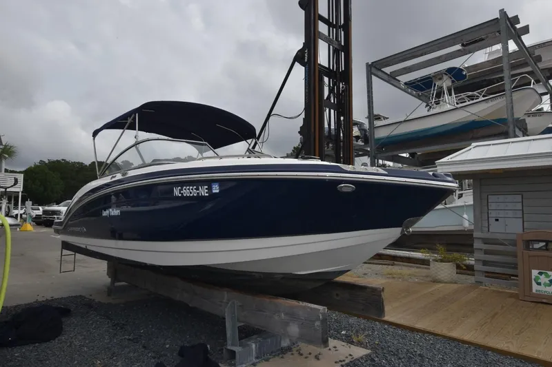 Slide: The Image of 2018 Chaparral 230 Suncoast boat on display at marina, blue hull, overcast sky. - 2