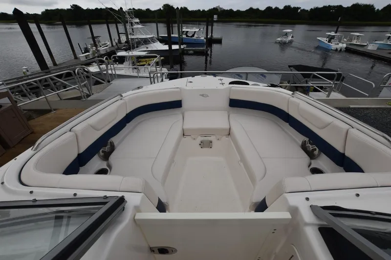 Slide: The Image of 2018 Chaparral 230 Suncoast boat interior with spacious seating at a marina. - 6