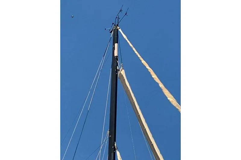 Slide: The Image of Mast of 2009 Class 40 Akilaria RC2 sailboat against clear blue sky. - 16
