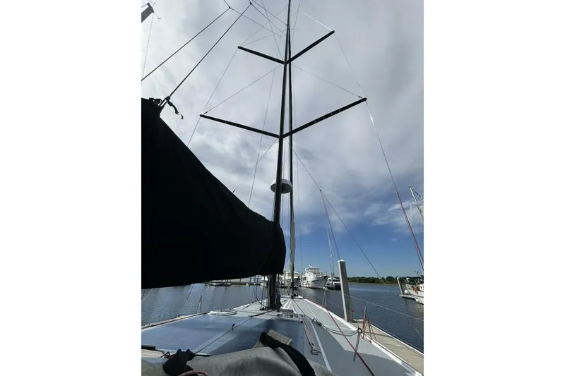Slide: The Image of Sailboat Akilaria RC2 Class 40, 2009 model, docked with tall mast under cloudy sky. - 38