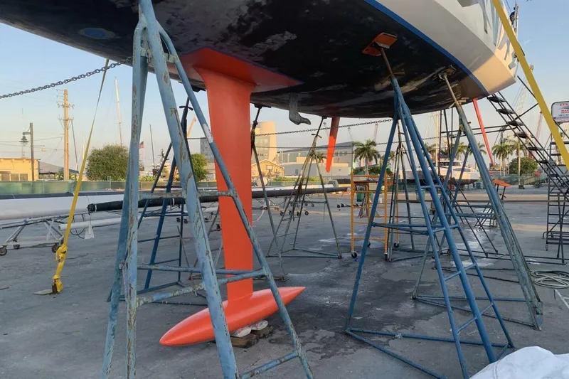 Slide: The Image of Sailboat Akilaria RC2 (2009) on stands, showcasing its vibrant orange keel. - 4