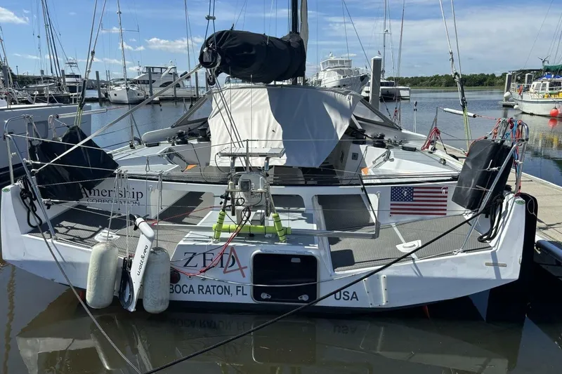 Slide: The Image of 2009 Class 40 Akilaria RC2 sailboat docked, featuring American flag and Boca Raton, FL registration. - 5