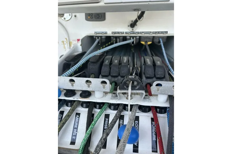 Slide: The Image of Control panel of 2009 Class 40 Akilaria RC2 sailboat with labeled ropes and levers. - 56