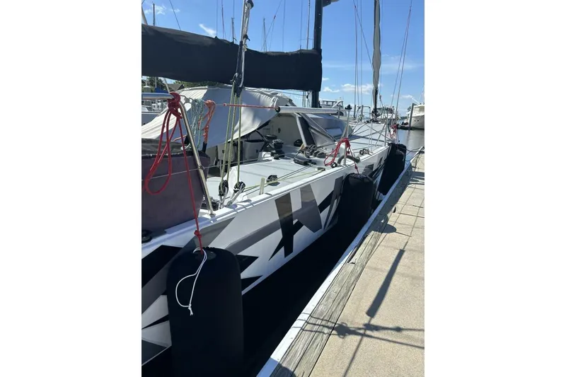 Slide: The Image of 2009 Akilaria RC2 Class 40 sailboat docked, featuring sleek design and vibrant rigging. - 76