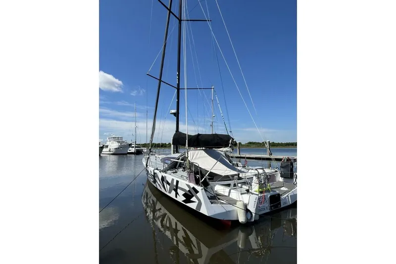 Slide: The Image of Sailboat Akilaria RC2 Class 40, 2009 model, docked in a marina under clear blue skies. - 80