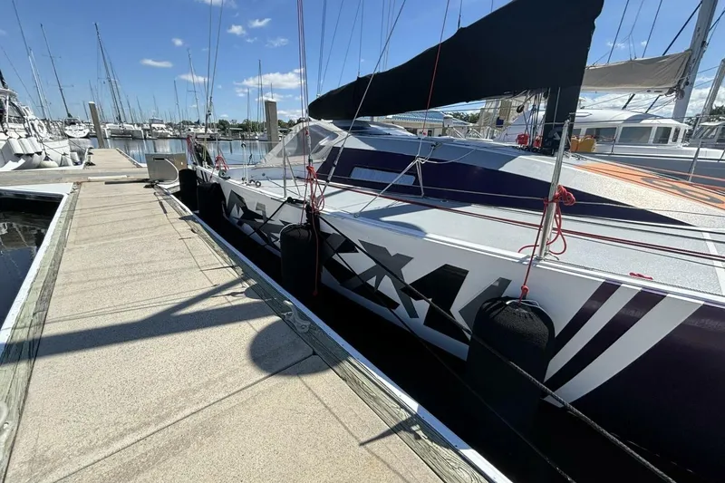 Slide: The Image of 2009 Class 40 Akilaria RC2 sailboat docked at marina under clear blue sky. - 83