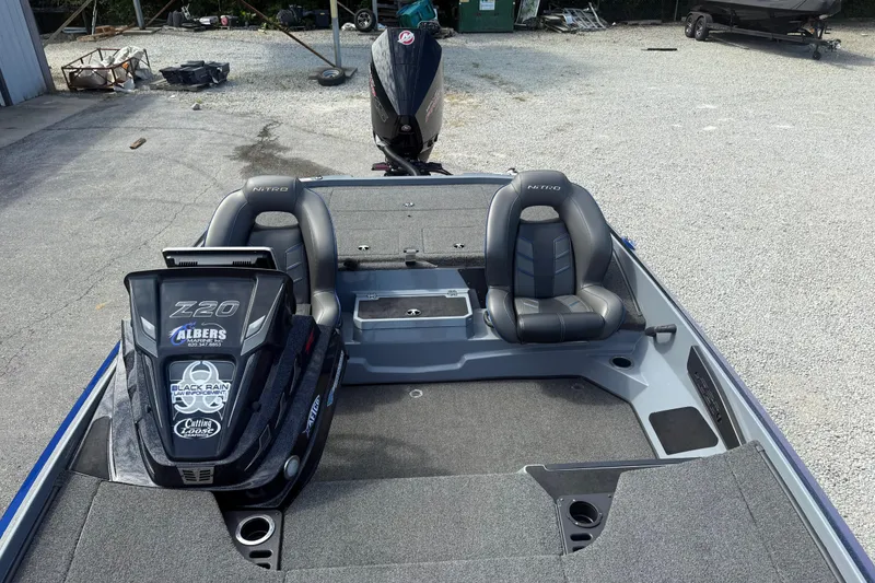 Slide: The Image of 2021 Nitro Z20 Pro boat interior with dual seats and motor, parked on gravel. - 23