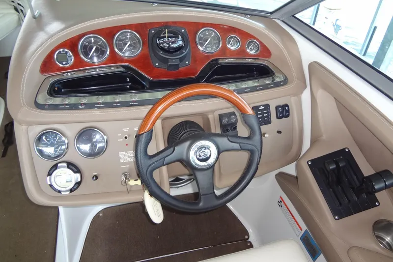 Slide: The Image of 2008 Cobalt 302 boat dashboard with wood accents and steering wheel. - 18