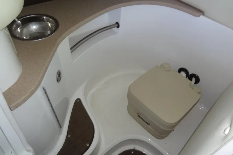 Slide: The Image of 2008 Cobalt 302 boat interior with compact toilet and sink area. - 23