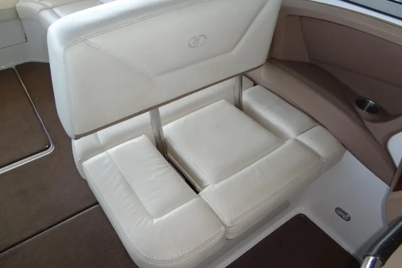 Slide: The Image of 2008 Cobalt 302 boat interior with white cushioned seating and brown accents. - 24