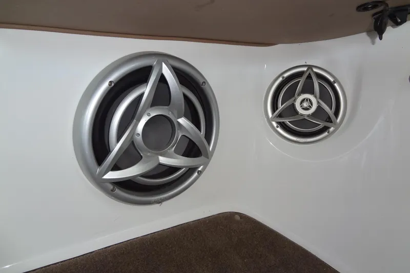 Slide: The Image of 2008 Cobalt 302 boat speakers with silver trim on white interior panel. - 38