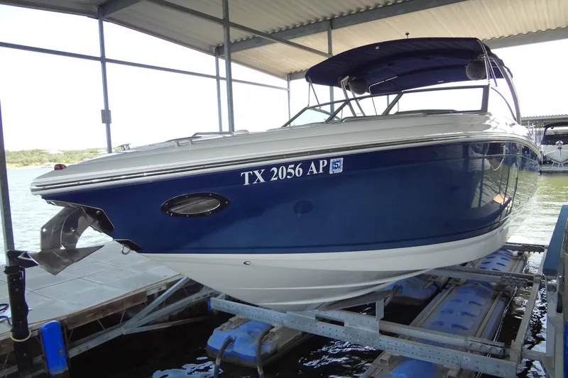 Slide: The Image of 2008 Cobalt 302 boat in dock, blue and white exterior, covered canopy. - 5