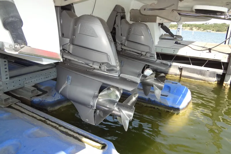 Slide: The Image of 2008 Cobalt 302 boat with dual propellers docked on a blue platform. - 53