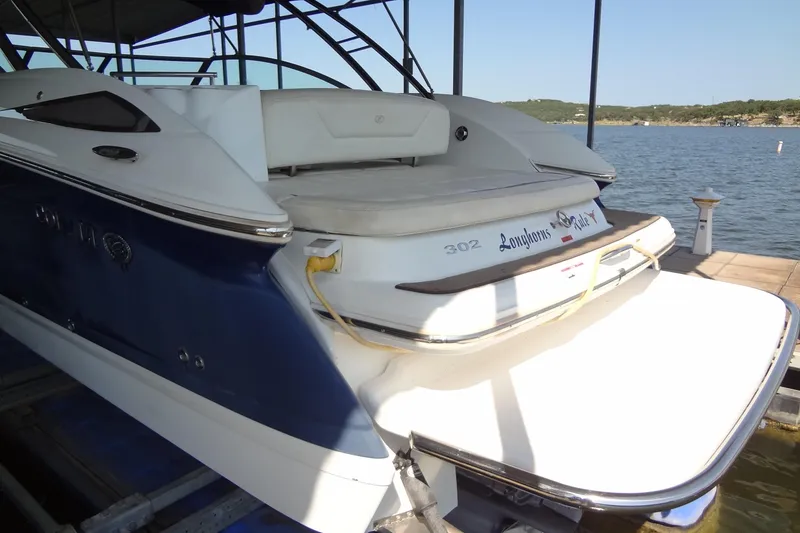 Slide: The Image of 2008 Cobalt 302 boat docked by a scenic lake, featuring a spacious swim platform. - 7