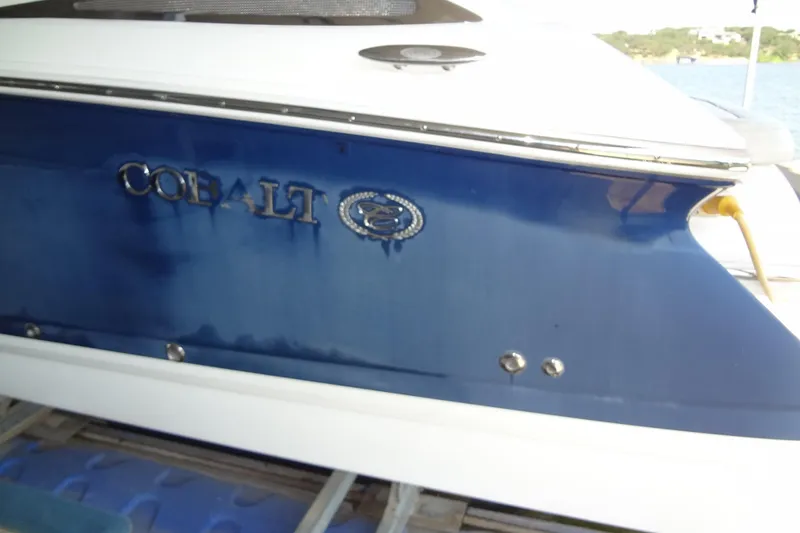 Slide: The Image of 2008 Cobalt 302 boat, blue and white exterior, docked by the water. - 8