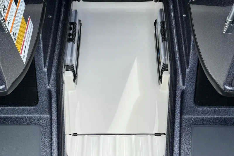 Slide: The Image of Open storage compartment in 2025 Lund 189 Tyee GL boat, featuring carpeted interior. - 13