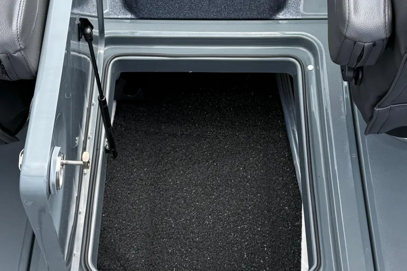 Slide: The Image of 2025 Lund 189 Tyee GL boat storage compartment with carpeted interior and secure latch. - 14