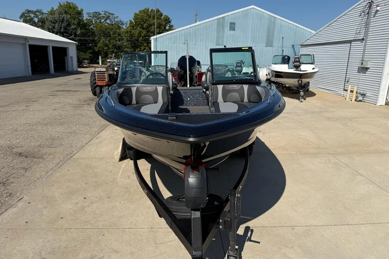 Slide: The Image of 2026 Lund 189 Tyee GL boat on trailer, parked outdoors near buildings. - 2