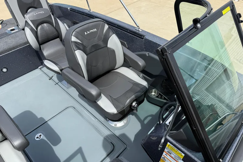 Slide: The Image of 2025 Lund 189 Tyee GL boat cockpit with steering wheel and dashboard controls. - 20