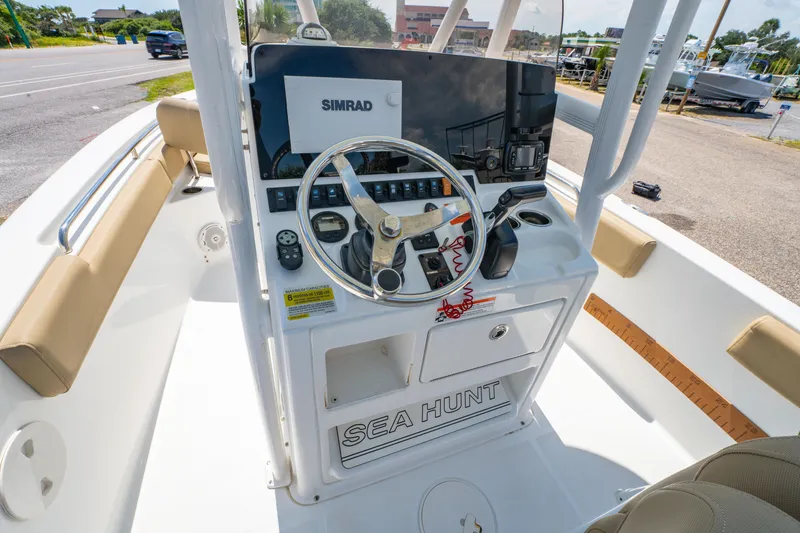Slide: The Image of 2017 Sea Hunt Ultra 225 boat dashboard with steering wheel and Simrad display. - 17