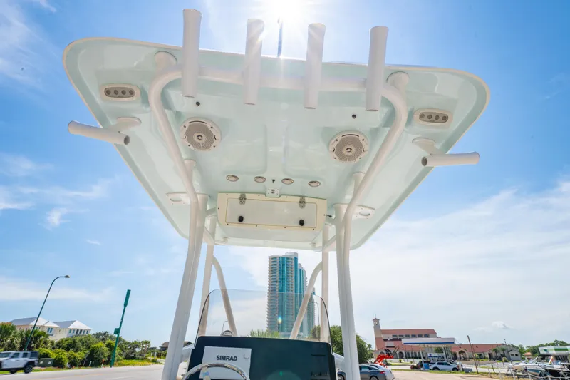 Slide: The Image of 2017 Sea Hunt Ultra 225 boat with T-top and rod holders under clear blue sky. - 22