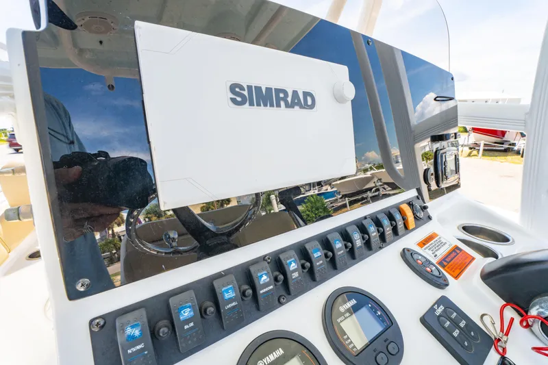 Slide: The Image of 2017 Sea Hunt Ultra 225 dashboard with Simrad navigation system and control panel. - 24