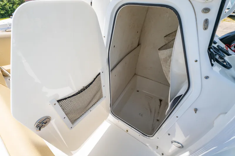 Slide: The Image of 2017 Sea Hunt Ultra 225 boat storage compartment with open door and netted pocket. - 27