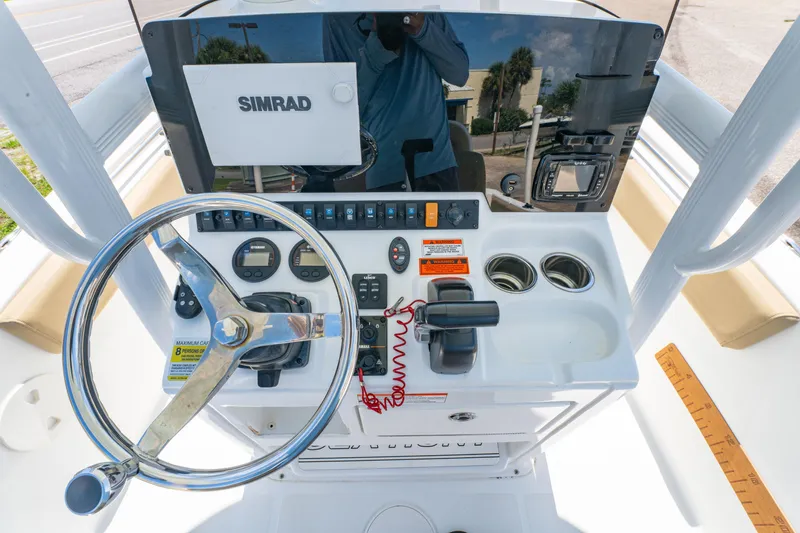 Slide: The Image of 2017 Sea Hunt Ultra 225 boat dashboard with steering wheel and Simrad navigation system. - 9