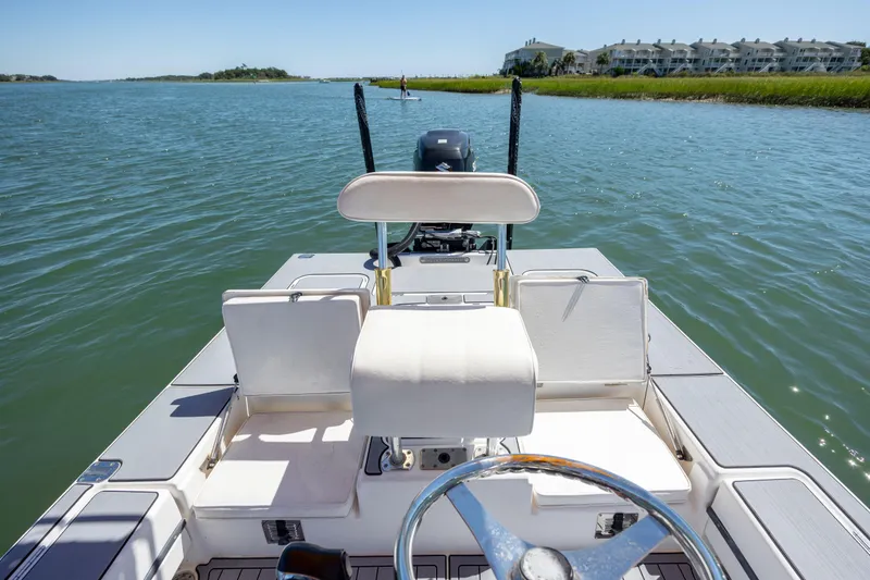 Slide: The Image of 2008 Release Tarpen Bay 21 boat on calm water, featuring a steering wheel and seating. - 14