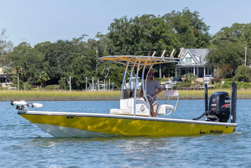 Slide: The Image of 2008 Release Tarpen Bay 21 boat on water, featuring a yellow hull and Suzuki outboard motor. - 2