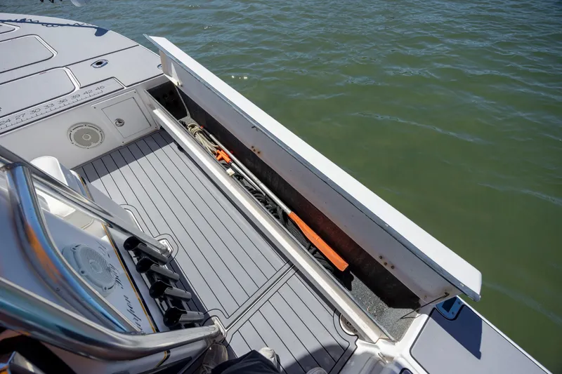 Slide: The Image of 2008 Release Tarpen Bay 21 boat deck with open storage compartment by the water. - 20