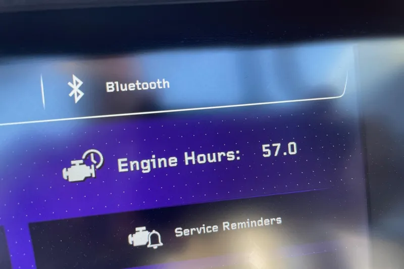 Slide: The Image of 2024 Nautique Super Air G25 Paragon display showing 57 engine hours and Bluetooth connectivity. - 13