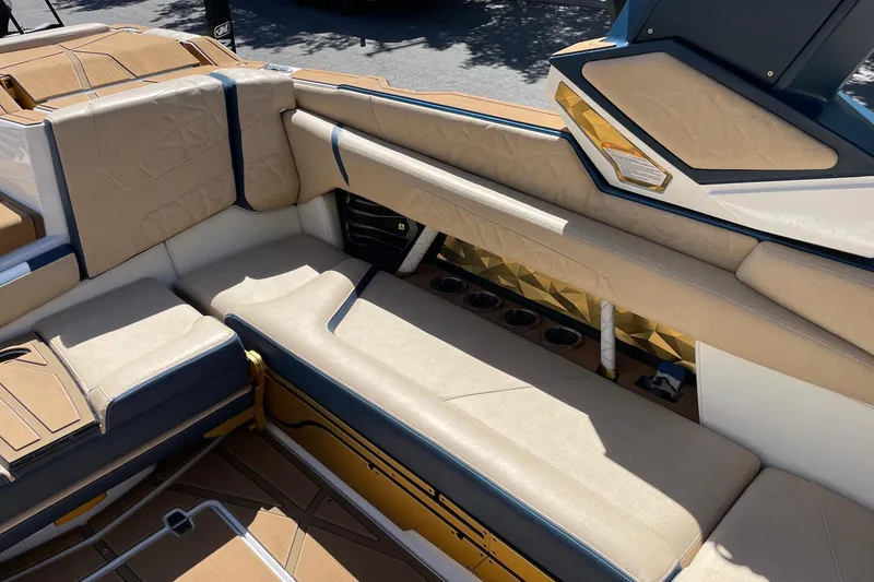 Slide: The Image of 2024 Nautique Super Air Nautique G25 Paragon interior with beige seating and cup holders. - 9