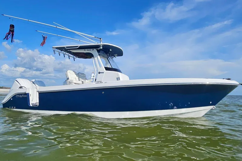 The Image of 2023 Edgewater 262CC boat on water, blue hull, clear sky background. - 1