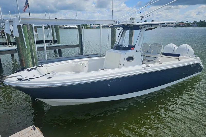 Slide: The Image of 2023 Edgewater 262CC boat docked, featuring sleek design and dual engines. - 2