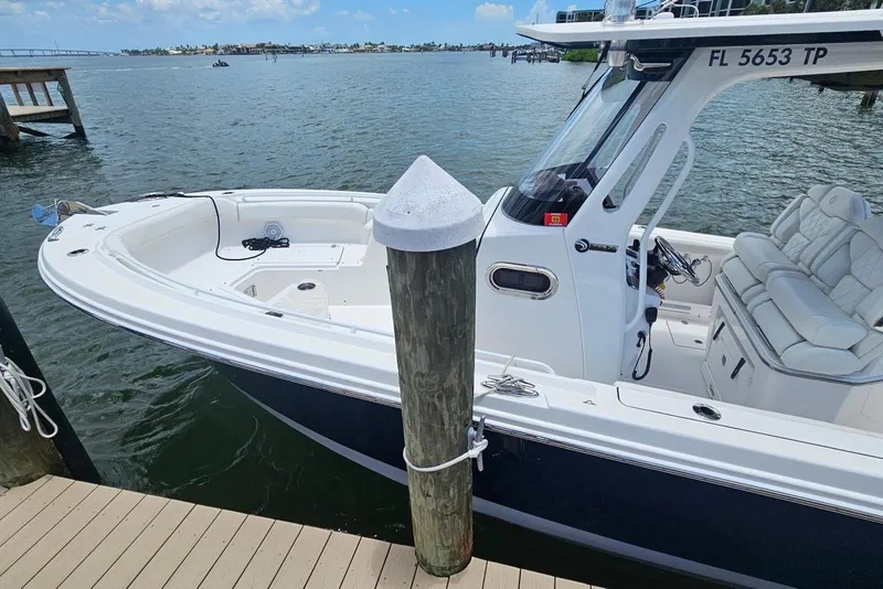 Slide: The Image of 2023 Edgewater 262CC boat docked by the water, featuring sleek design and comfortable seating. - 4