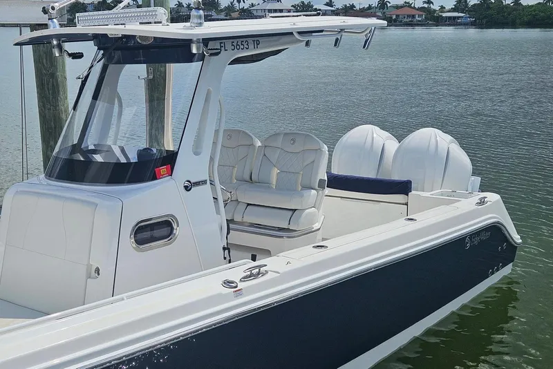 Slide: The Image of 2023 Edgewater 262CC boat with dual engines docked on calm water. - 5