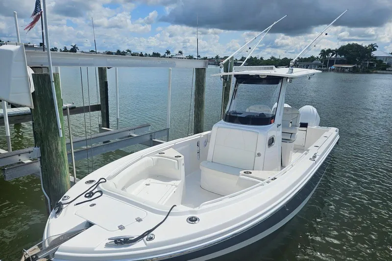 Slide: The Image of 2023 Edgewater 262CC boat docked on calm water under cloudy sky. - 6