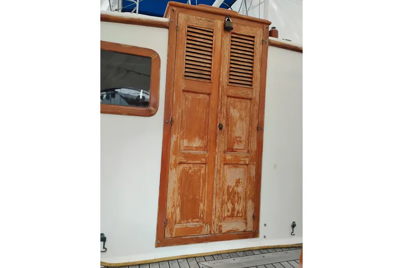Slide: The Image of Wooden door on 1979 Transpac Eagle 36 Trawler, featuring weathered finish and nautical design. - 10