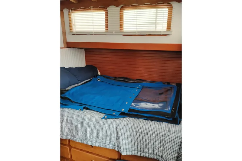 Slide: The Image of Interior cabin of 1979 Transpac Eagle 36 Trawler with bed and blue cover. - 12