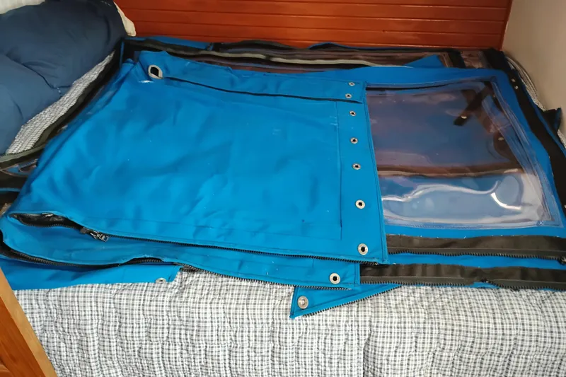 Slide: The Image of Blue canvas cover with clear window on a bed inside a 1979 Transpac Eagle 36 Trawler. - 13