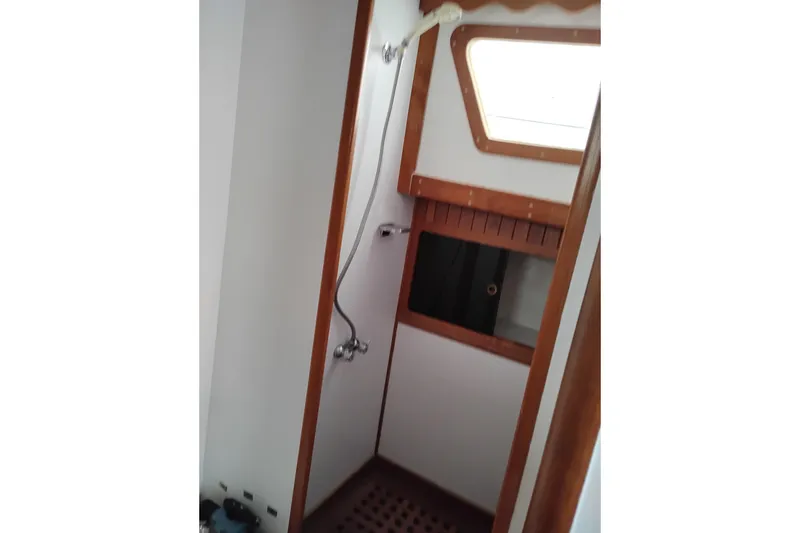 Slide: The Image of 1979 Transpac Eagle 36 Trawler shower area with wooden accents and window. - 18